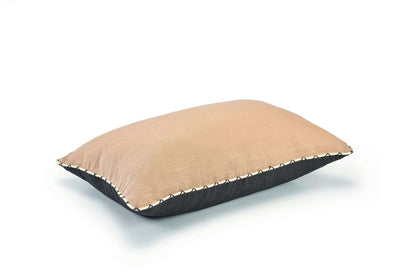 Beige pillow with black border on a white background